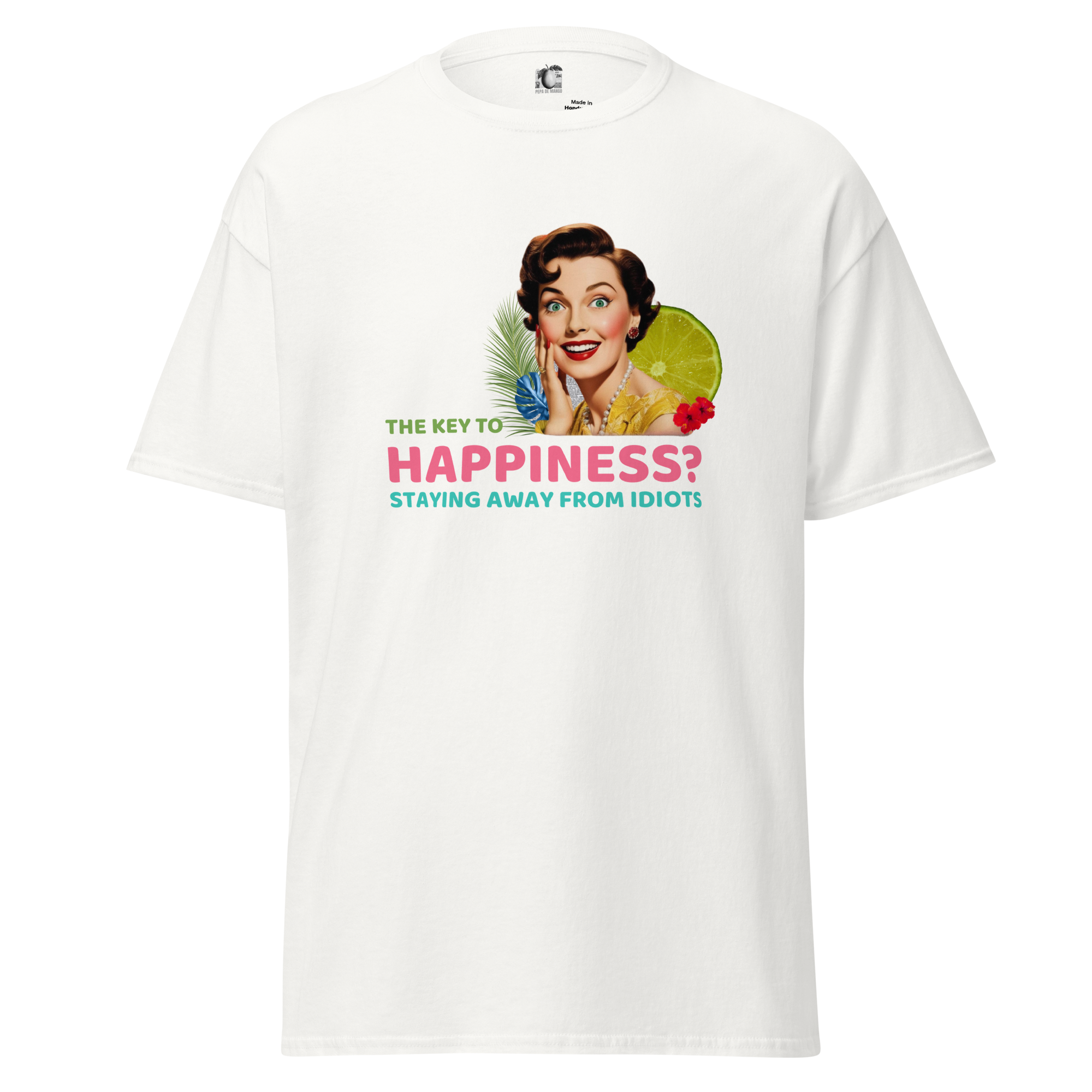Front view of a white unisex statement t-shirt by Pepa de Mango, featuring the phrase “The key to happiness? Staying away from idiots” in bold text with a retro collage of a smiling woman, lime, and tropical florals.